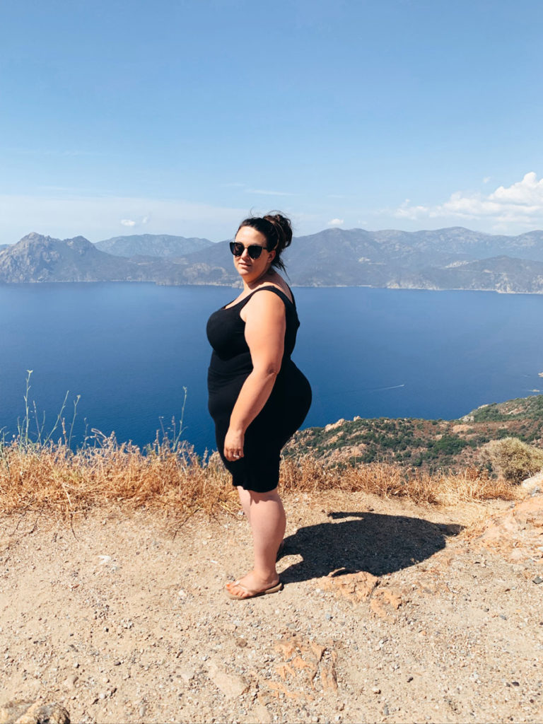plus size fat woman traveling and standing on the cliffs of corsica france